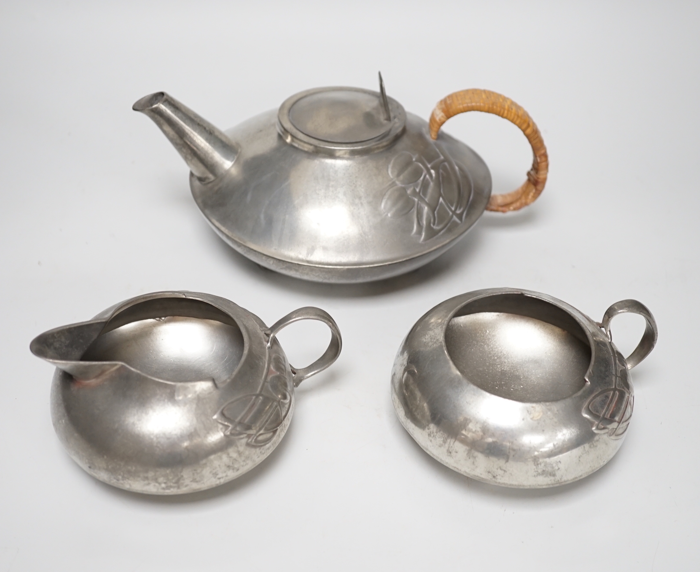 Art Nouveau Archibald Knox for Liberty, Tudric pewter three piece tea set, the teapot with woven handle, each stamped 0231 to the base, the largest 23cm wide